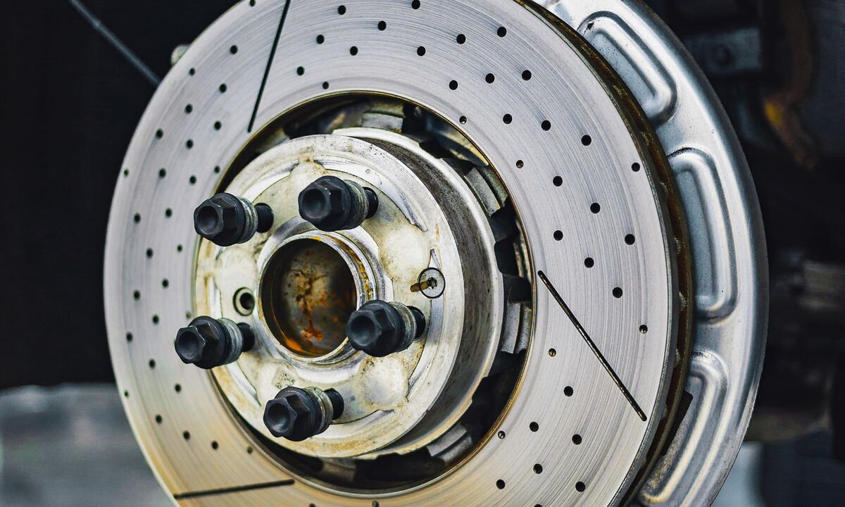 Car parts on a shelf: battery, oil, filters and brake discs
